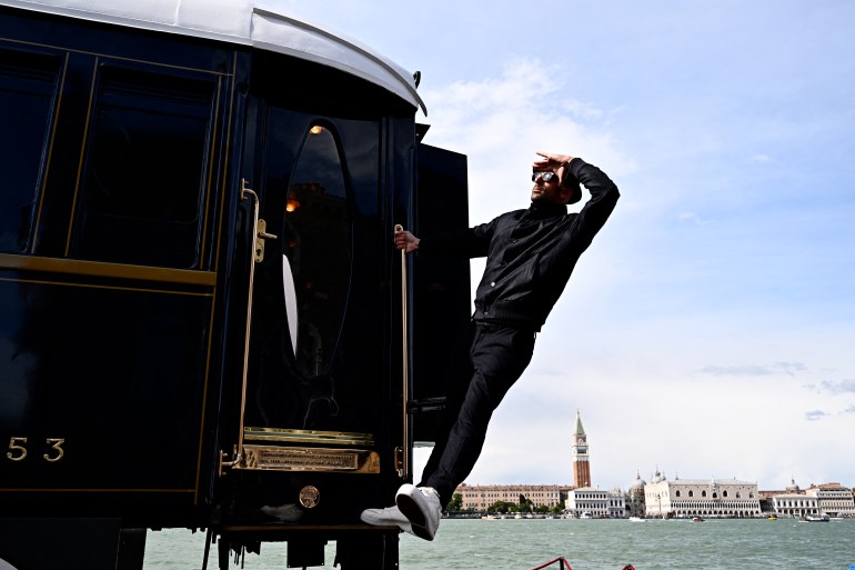 French artist JR is pictured next to a carriage-sized suite called L'Observatoire onboard the Venice Simplon-Orient-Express, in the garden of the Cipriani Hotel, on the sidelines of the Venice Biennale art show, on April 18, 2024 in Venice. (Photo by GABRIEL BOUYS / AFP) / RESTRICTED TO EDITORIAL USE - MANDATORY MENTION OF THE ARTIST UPON PUBLICATION - TO ILLUSTRATE THE EVENT AS SPECIFIED IN THE CAPTION